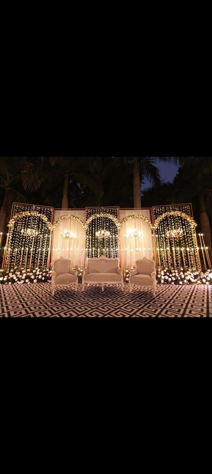 Elegant wedding stage with floral arches and chandeliers